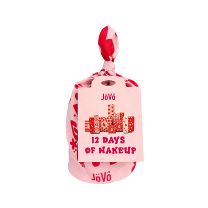 Calendario de Adviento Jövö 12 Days of Makeup en bolsa rosa con detalles rojos y mensaje Have a Good Day.